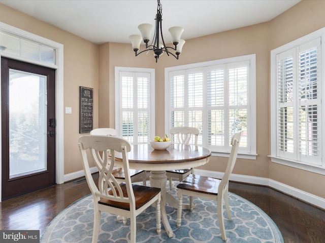 dining area featuring a notable chandelier, a healthy amount of sunlight, and dark wood-type flooring