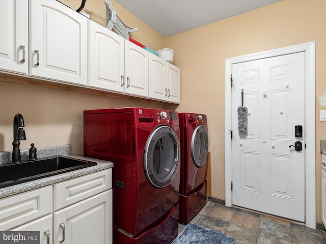 laundry room with sink, washing machine and dryer, and cabinets