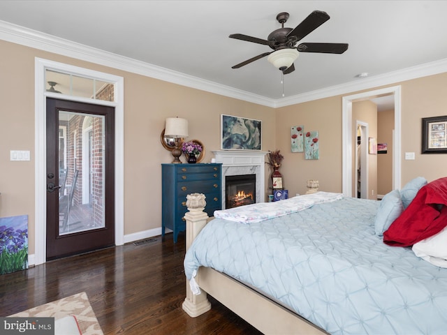 bedroom featuring dark hardwood / wood-style floors, access to outside, ornamental molding, a high end fireplace, and ceiling fan