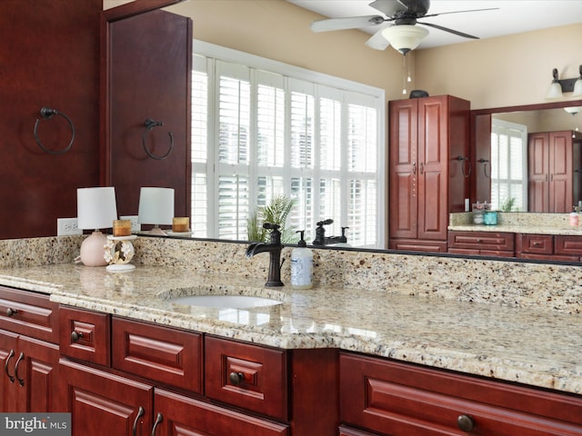 kitchen featuring sink, light stone countertops, and ceiling fan