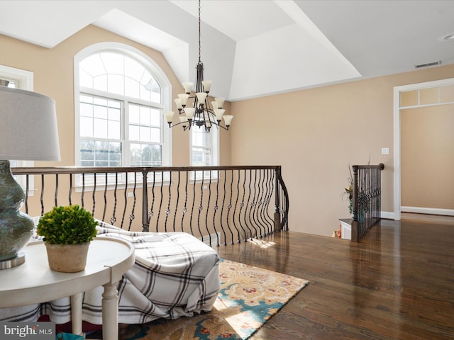 living area with a notable chandelier, lofted ceiling, and dark hardwood / wood-style floors