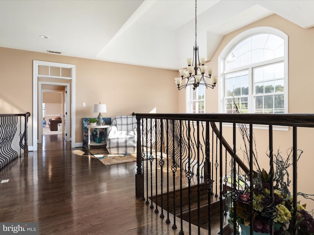 hall featuring dark wood-type flooring and a notable chandelier