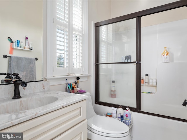 full bathroom with vanity, toilet, and bath / shower combo with glass door