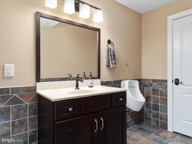 bathroom with vanity and tile walls