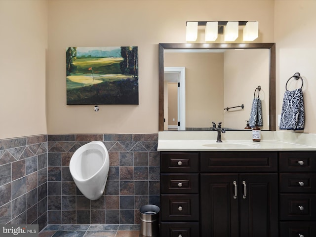 bathroom featuring vanity and tile walls