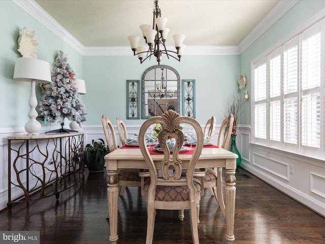 dining area with dark wood-type flooring, ornamental molding, and an inviting chandelier