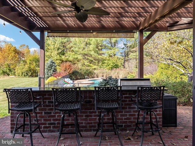 view of patio with ceiling fan, a bar, and a pergola