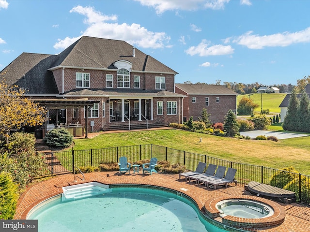 rear view of property with a patio, a lawn, and a swimming pool with hot tub