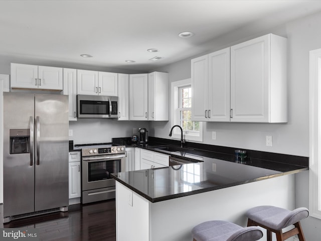 kitchen featuring kitchen peninsula, white cabinetry, and stainless steel appliances