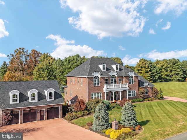 french country style house with a front yard, a garage, and a balcony