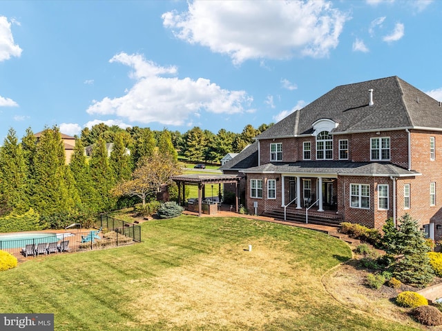 back of house featuring a yard, a patio, and a pergola