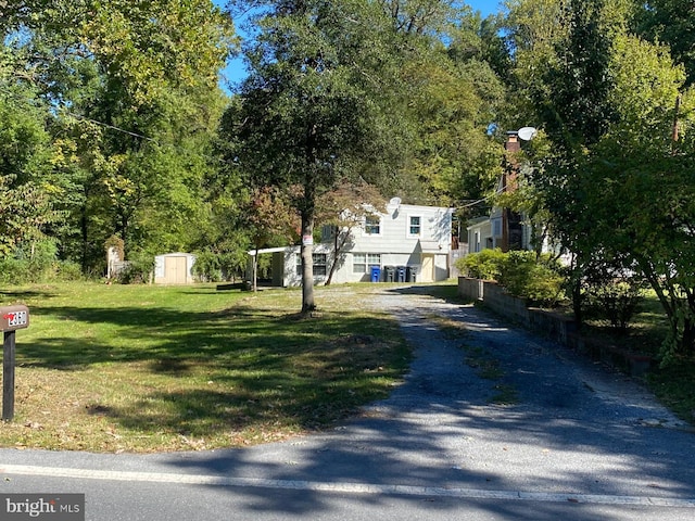 view of front of home with a front lawn and a storage unit