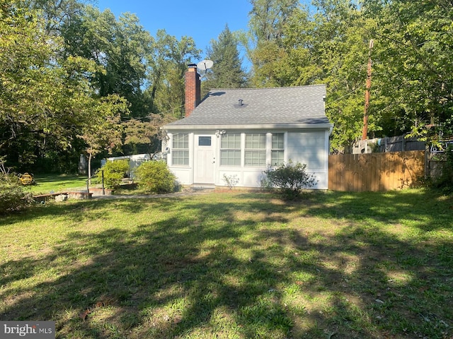 rear view of property with a yard