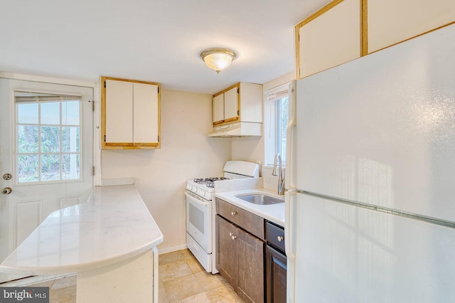 kitchen with kitchen peninsula, white appliances, and sink