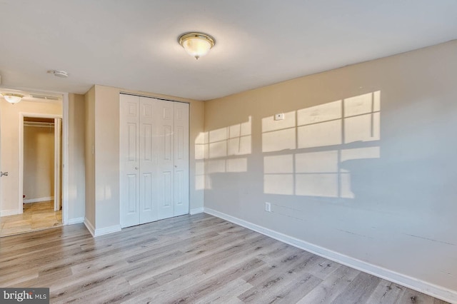 unfurnished bedroom featuring light hardwood / wood-style floors and a closet