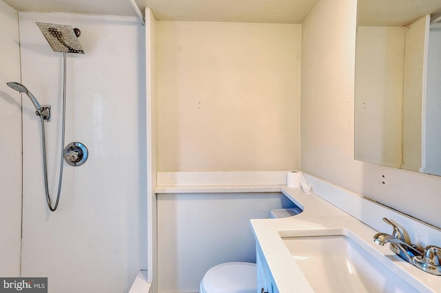 bathroom featuring toilet, vanity, and walk in shower