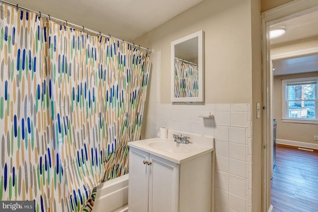 bathroom with vanity, shower / bath combination with curtain, and tile walls