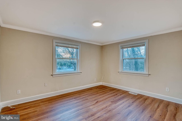 unfurnished room with plenty of natural light, light hardwood / wood-style floors, and ornamental molding