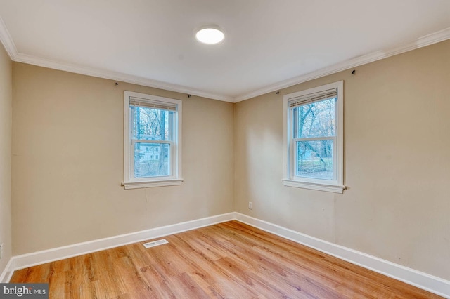 empty room with light wood-type flooring and ornamental molding