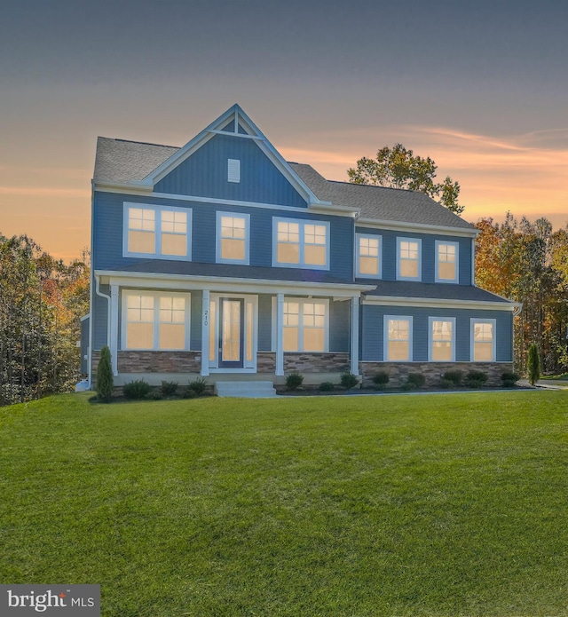 back house at dusk featuring a yard