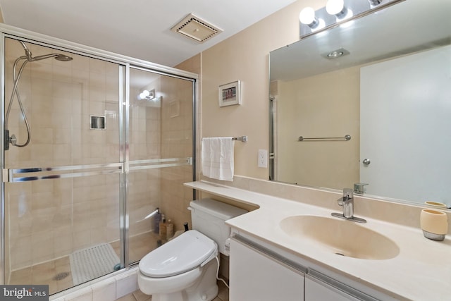 bathroom featuring tile patterned flooring, vanity, toilet, and a shower with shower door