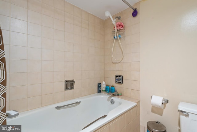 bathroom featuring tiled shower / bath and toilet