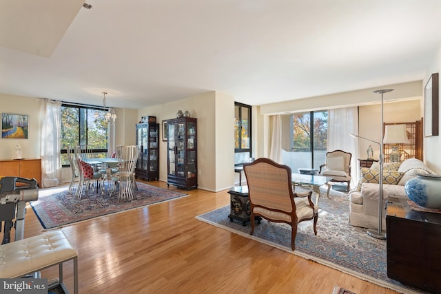 living room with light hardwood / wood-style flooring, a healthy amount of sunlight, and a chandelier