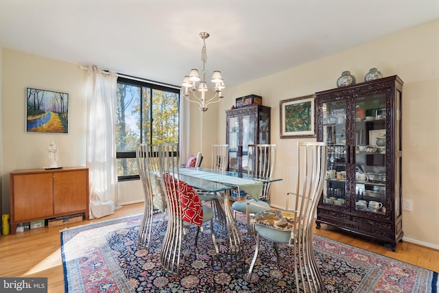 dining room with light hardwood / wood-style floors and an inviting chandelier