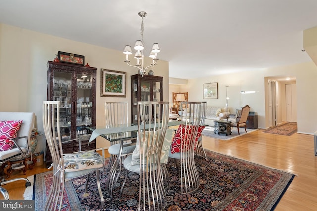 dining area featuring light hardwood / wood-style flooring and an inviting chandelier