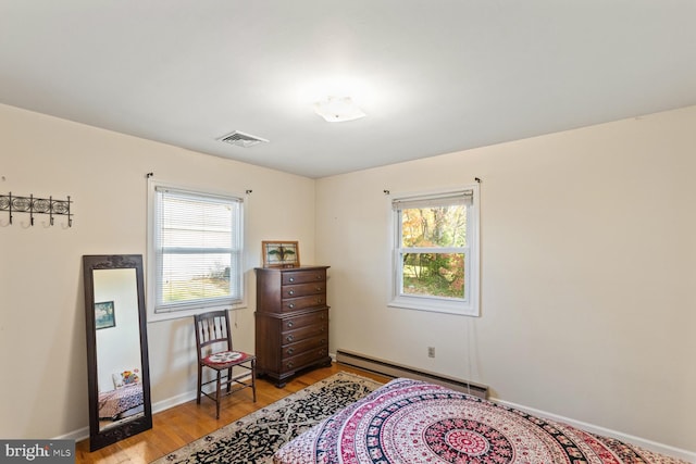 sitting room featuring baseboard heating, light hardwood / wood-style flooring, and plenty of natural light