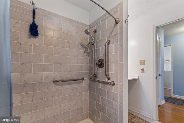 bathroom featuring a textured ceiling, curtained shower, and hardwood / wood-style flooring