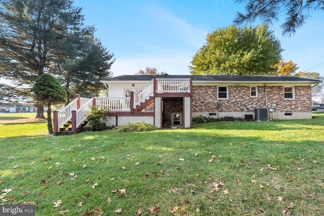 rear view of house with central AC, a deck, and a yard