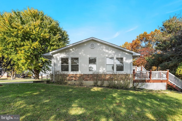 view of front of home featuring a front yard and a deck