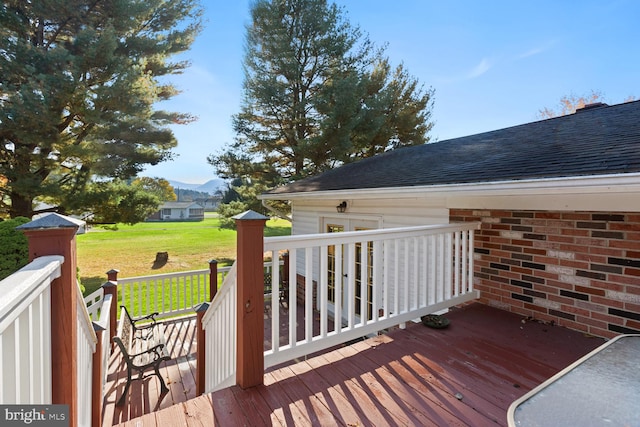 wooden deck with a yard and a mountain view