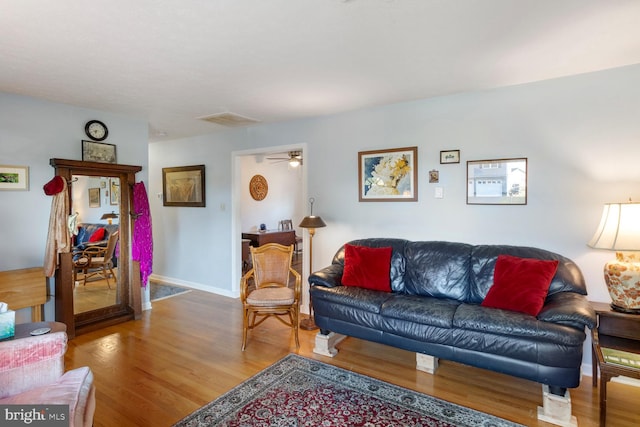 living room featuring wood-type flooring and ceiling fan