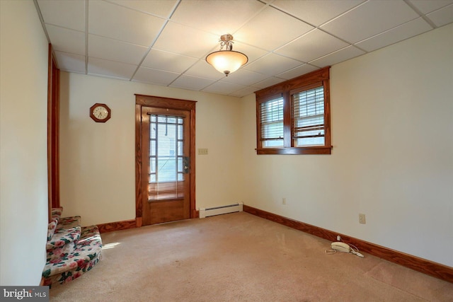 interior space featuring light carpet, baseboard heating, and a drop ceiling