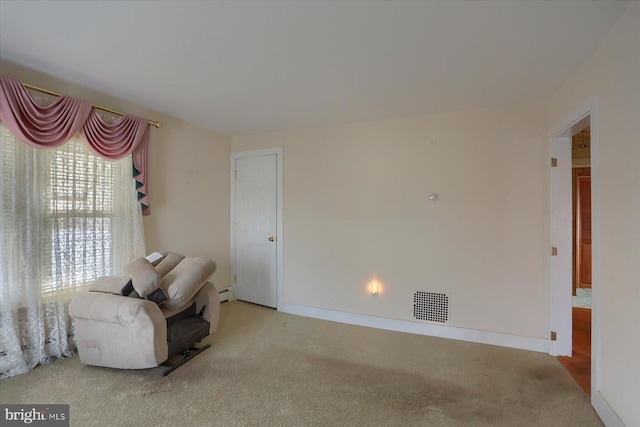 sitting room featuring a baseboard radiator, baseboards, visible vents, and carpet flooring