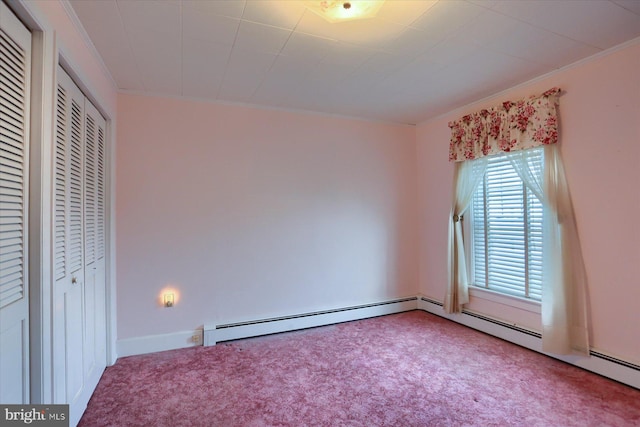 unfurnished bedroom with a baseboard heating unit, ornamental molding, and carpet flooring