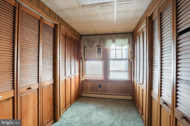 unfurnished sunroom with baseboard heating and a wall mounted air conditioner