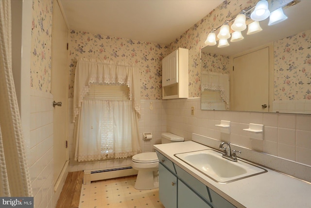 bathroom featuring a baseboard radiator, toilet, a wainscoted wall, tile patterned floors, and wallpapered walls