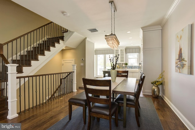 dining area with sink, a chandelier, crown molding, and dark hardwood / wood-style floors