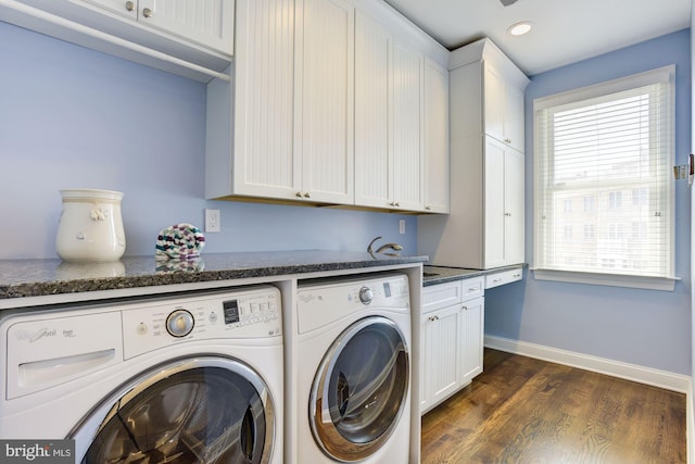 laundry area with washing machine and dryer, cabinets, and dark hardwood / wood-style floors