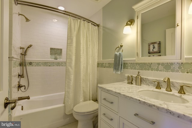 full bathroom with vanity, toilet, tile walls, and shower / tub combo with curtain