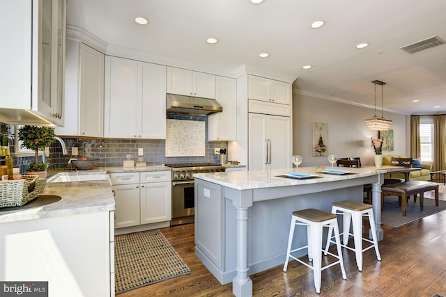 kitchen featuring high quality appliances, a center island, dark hardwood / wood-style floors, and white cabinets