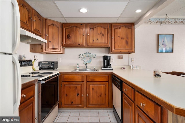 kitchen featuring a paneled ceiling, sink, light tile patterned floors, and white appliances