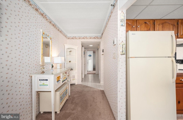 corridor with carpet flooring and a drop ceiling