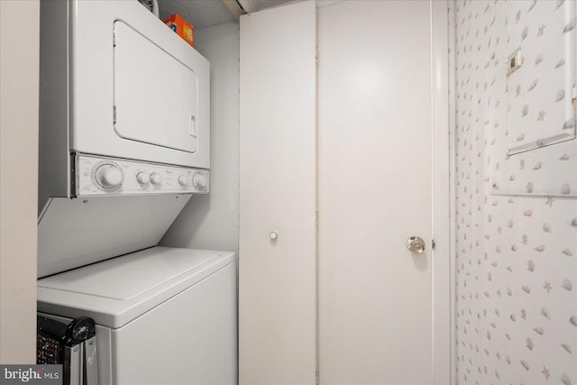 laundry area featuring stacked washer / drying machine