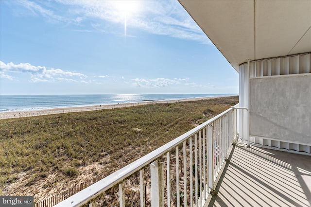 balcony with a water view and a view of the beach