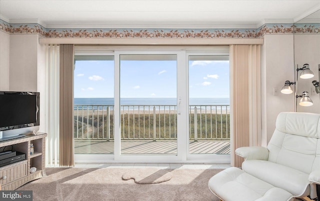 interior space featuring ornamental molding, a water view, and a beach view