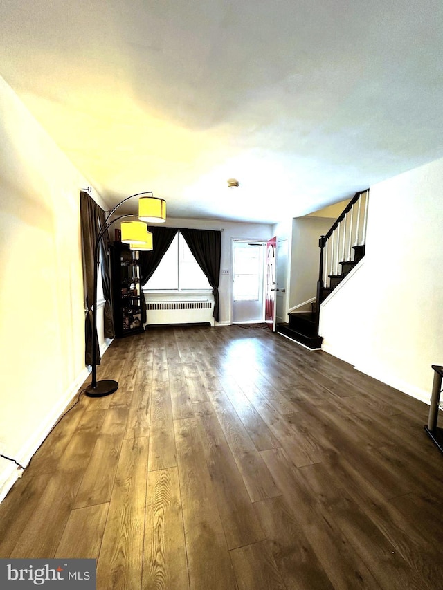 interior space featuring dark hardwood / wood-style flooring and radiator heating unit